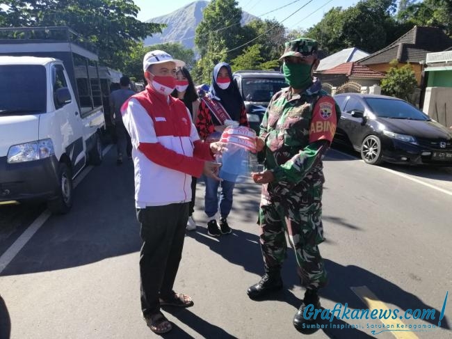 Rudi Hidayat, Ketua litbang JMSI sekaligus anggota INTI NTB membagikan face shield di sembalun